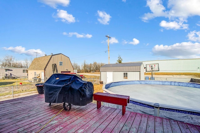 wooden deck with an outbuilding, fence, grilling area, and a storage shed