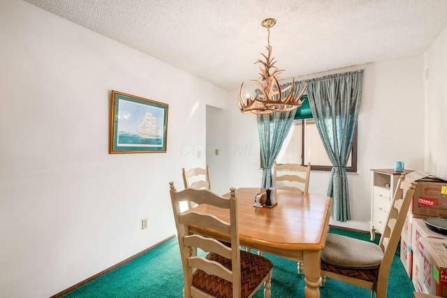 dining room featuring a textured ceiling, carpet floors, and a chandelier