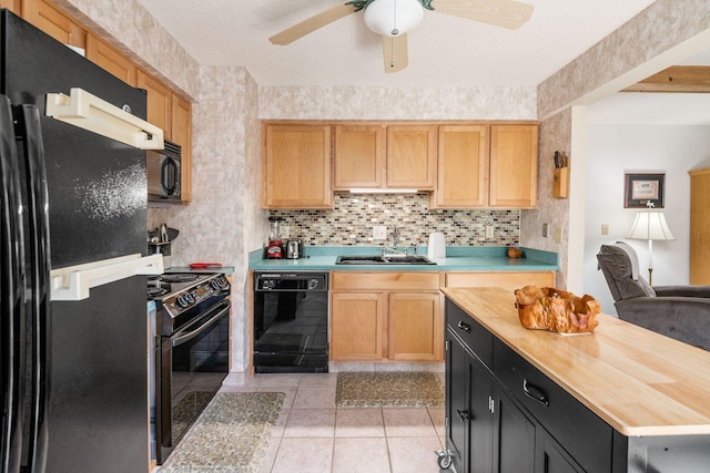 kitchen with decorative backsplash, a sink, wooden counters, and black appliances