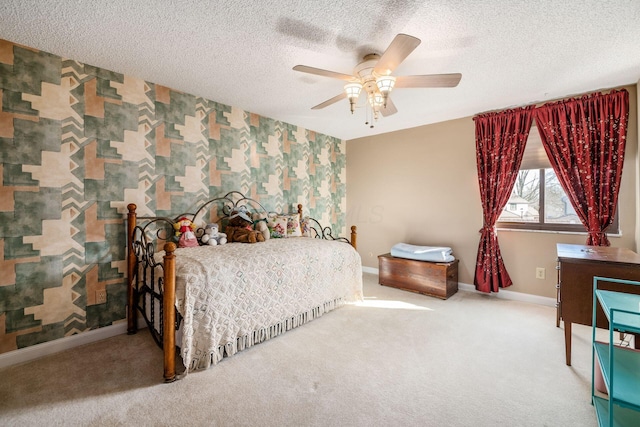 bedroom with a textured ceiling, an accent wall, baseboards, carpet, and wallpapered walls