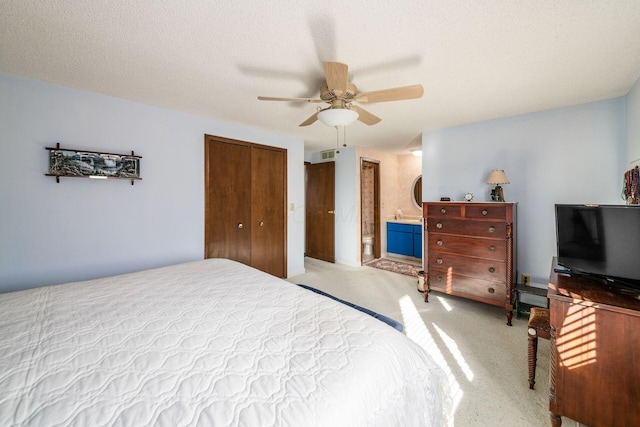 carpeted bedroom featuring a ceiling fan, a closet, visible vents, and a textured ceiling