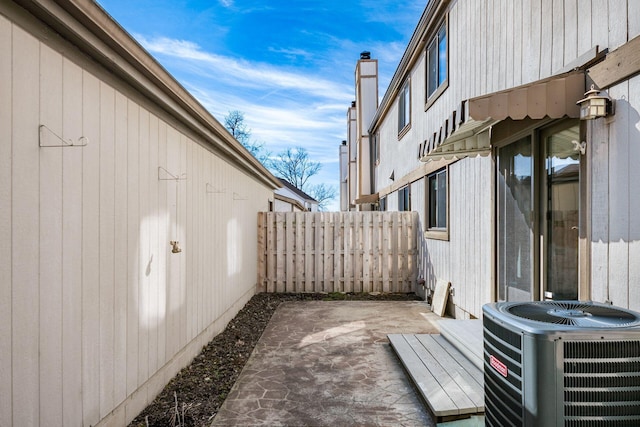 view of patio / terrace featuring central air condition unit and fence