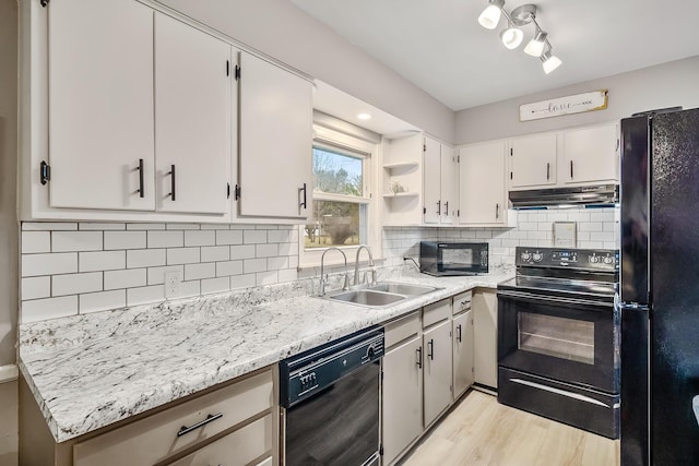 kitchen featuring backsplash, under cabinet range hood, a sink, and black appliances