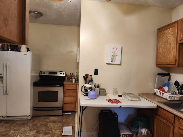 kitchen featuring white fridge with ice dispenser, electric stove, brown cabinets, and a textured ceiling