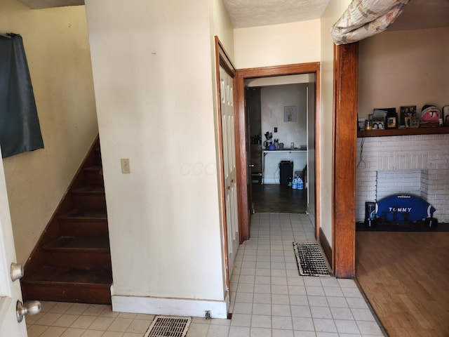 hall with light tile patterned floors and stairs