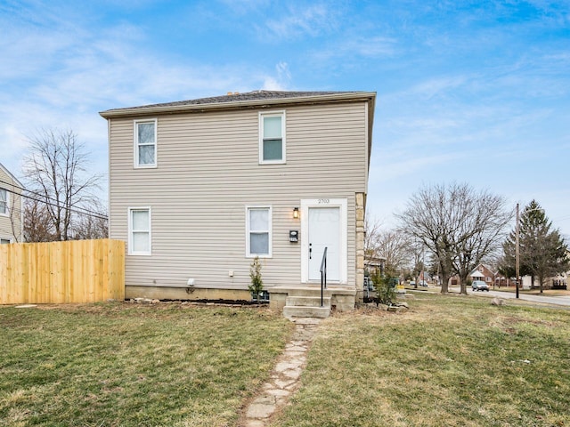 view of front facade featuring fence and a front lawn