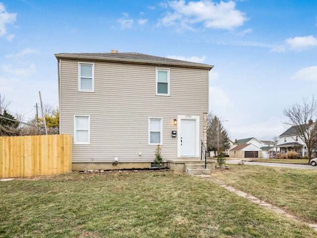 view of front of home with a front lawn and fence