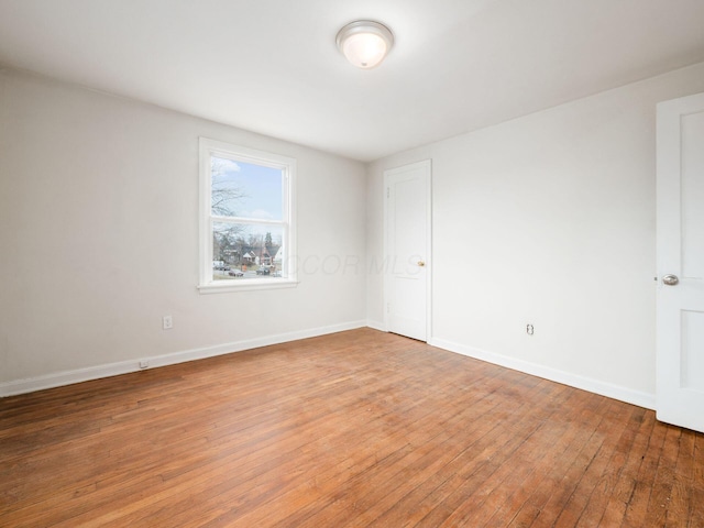 spare room featuring light wood finished floors and baseboards