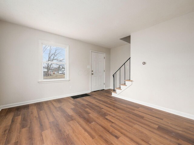 foyer entrance with stairs, wood finished floors, visible vents, and baseboards