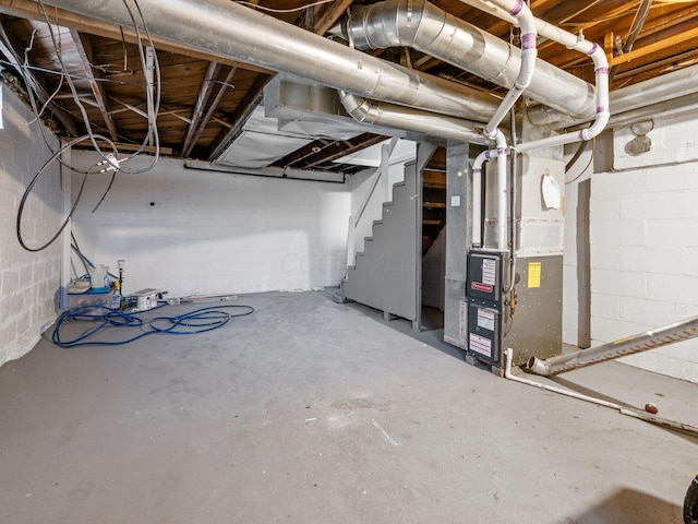 unfinished basement with heating unit and stairs