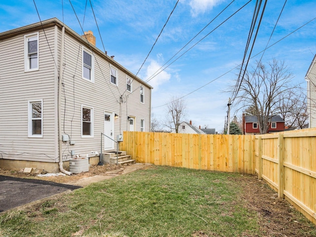 view of yard featuring fence and central air condition unit