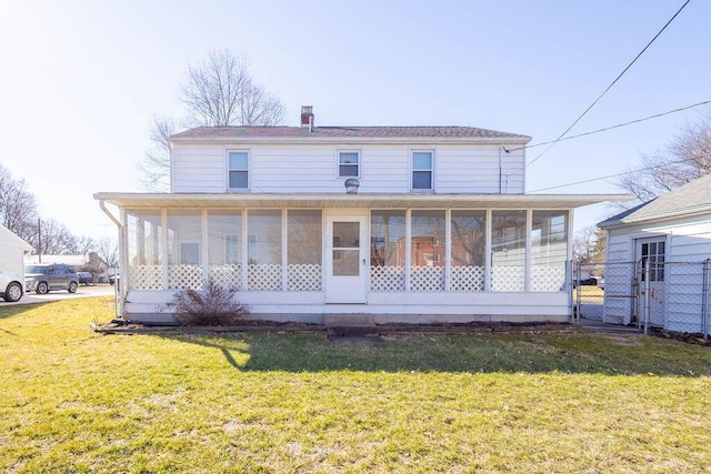 rear view of house featuring a sunroom, a gate, fence, and a yard