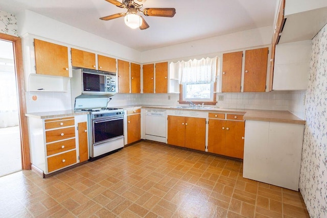 kitchen with light countertops, white appliances, backsplash, and a sink