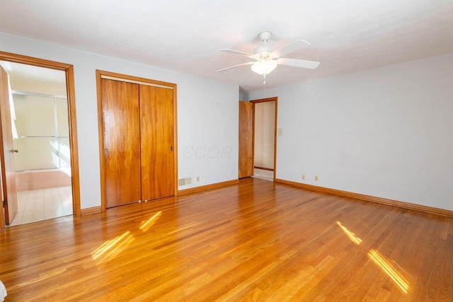 unfurnished bedroom featuring light wood-style floors, visible vents, baseboards, and a ceiling fan