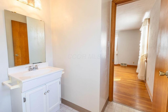 bathroom featuring baseboards, vanity, visible vents, and tile patterned floors