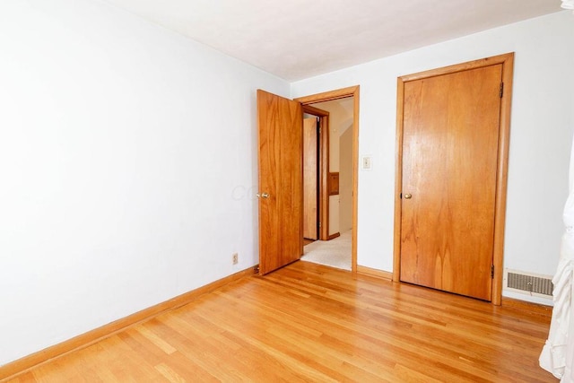 unfurnished bedroom featuring light wood-type flooring, visible vents, and baseboards