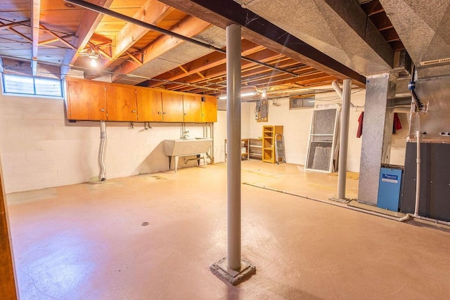 basement with a sink and concrete block wall