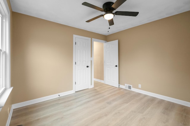 unfurnished bedroom with light wood-type flooring, visible vents, ceiling fan, and baseboards