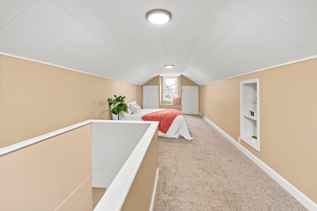 carpeted bedroom with vaulted ceiling and baseboards