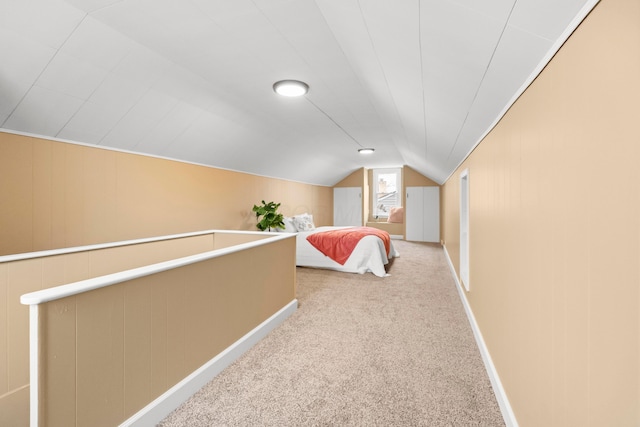 unfurnished bedroom featuring lofted ceiling, carpet flooring, and baseboards