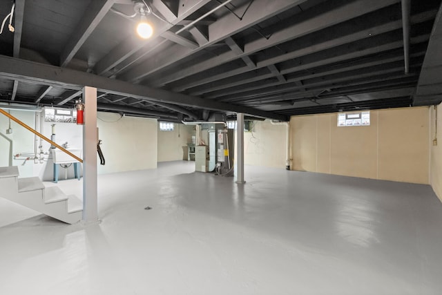 basement featuring water heater and stairway