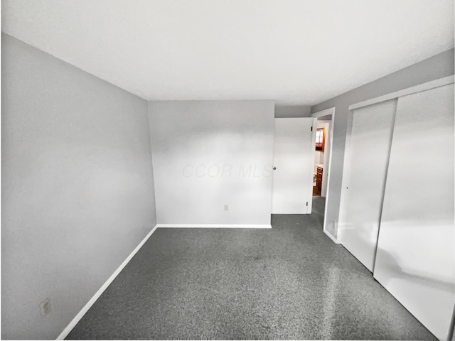 unfurnished bedroom featuring a closet, carpet flooring, and baseboards