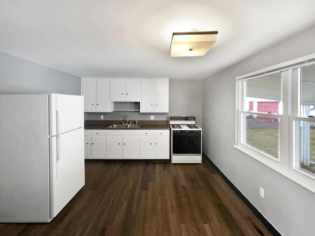 kitchen with dark wood-style flooring, dark countertops, white cabinetry, a sink, and white appliances