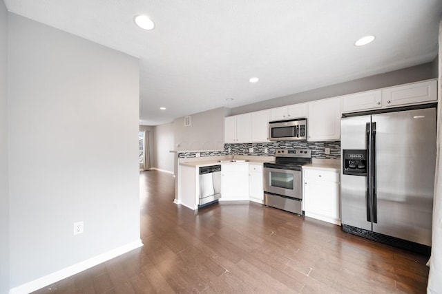 kitchen with stainless steel appliances, tasteful backsplash, dark wood finished floors, and white cabinets