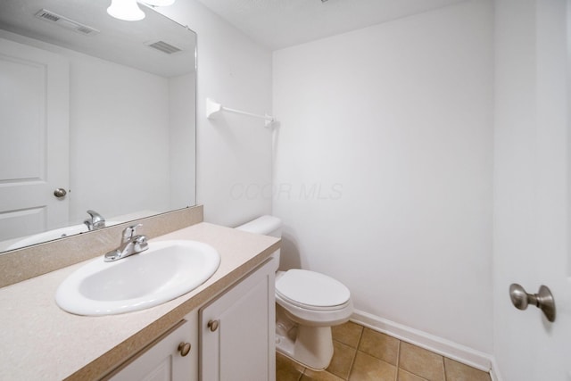 bathroom featuring toilet, vanity, tile patterned flooring, and visible vents