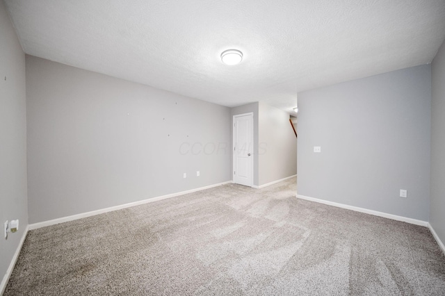 unfurnished room featuring carpet flooring, a textured ceiling, and baseboards