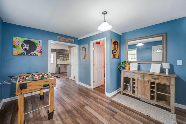 rec room featuring a healthy amount of sunlight, wood finished floors, and baseboards