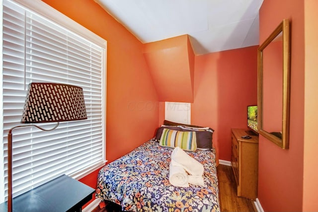 bedroom with baseboards and wood finished floors