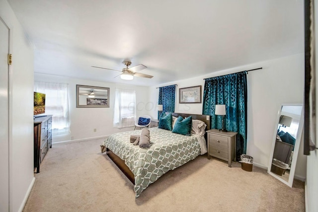 bedroom featuring light carpet, ceiling fan, and baseboards