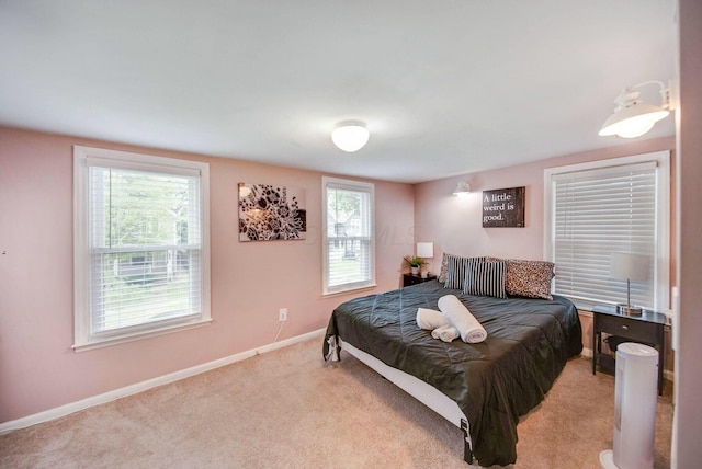 bedroom featuring light carpet and baseboards