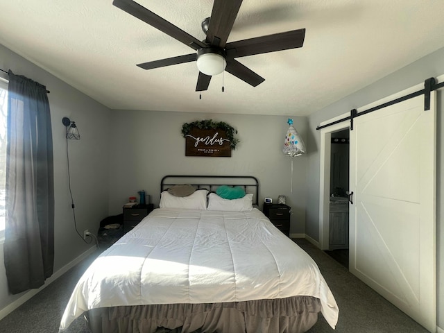 carpeted bedroom featuring a barn door, baseboards, ceiling fan, and a textured ceiling