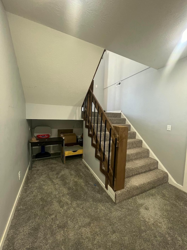 stairway with carpet floors, visible vents, baseboards, and a textured ceiling