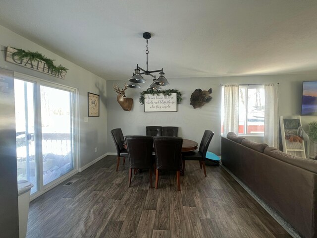 dining area featuring dark wood-style floors, visible vents, and baseboards