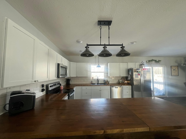 kitchen with stainless steel appliances, backsplash, plenty of natural light, and a sink