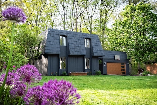 view of front facade with a garage, mansard roof, a front lawn, and board and batten siding