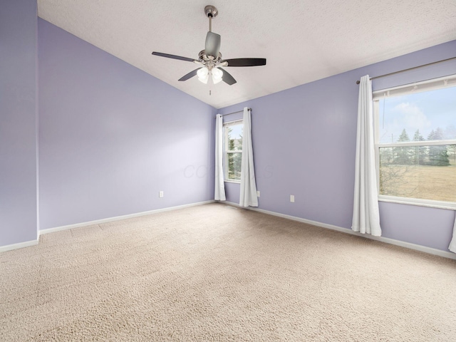 carpeted spare room with lofted ceiling, a textured ceiling, and baseboards