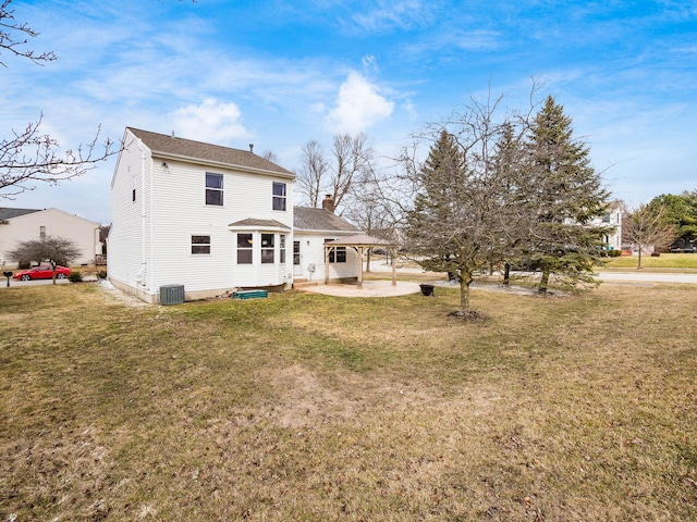 back of property featuring central AC, a yard, a chimney, and a patio area