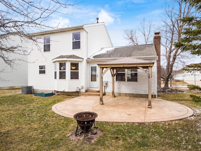 rear view of house with entry steps, a fire pit, a gazebo, a lawn, and a patio area