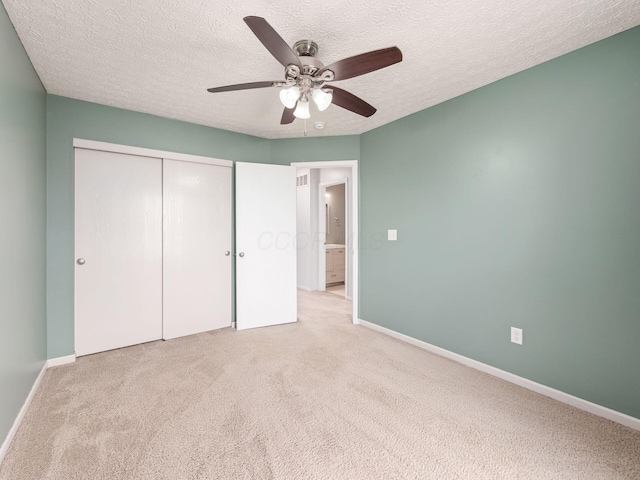 unfurnished bedroom with a textured ceiling, ceiling fan, carpet flooring, baseboards, and a closet