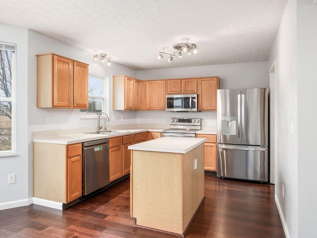 kitchen with stainless steel appliances, light countertops, a sink, and dark wood finished floors