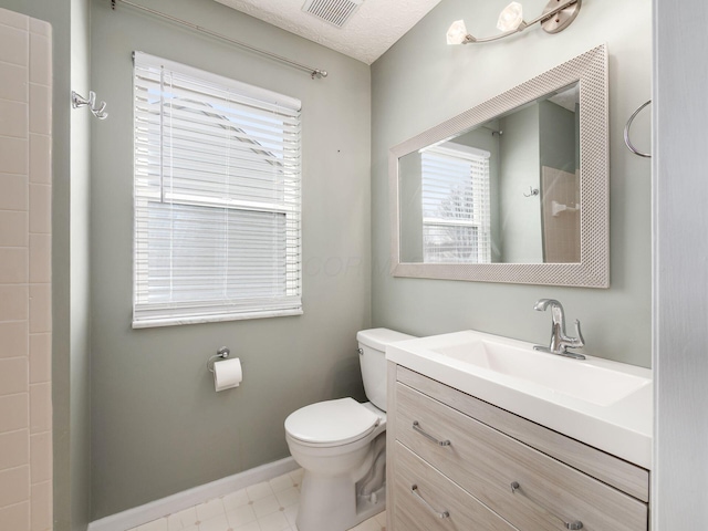 bathroom with a textured ceiling, toilet, vanity, visible vents, and baseboards