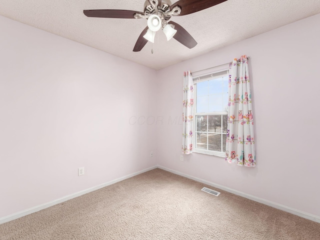 carpeted empty room with a ceiling fan, visible vents, a textured ceiling, and baseboards