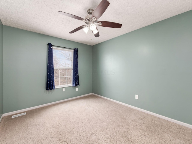 unfurnished room featuring a textured ceiling, ceiling fan, carpet flooring, visible vents, and baseboards