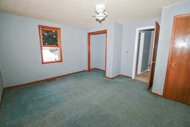 carpeted empty room with baseboards and a textured ceiling