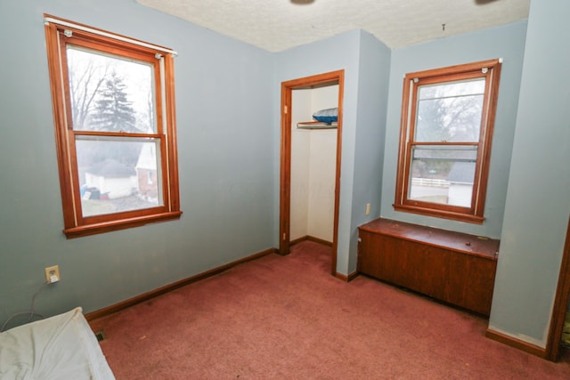 carpeted bedroom with a textured ceiling and baseboards