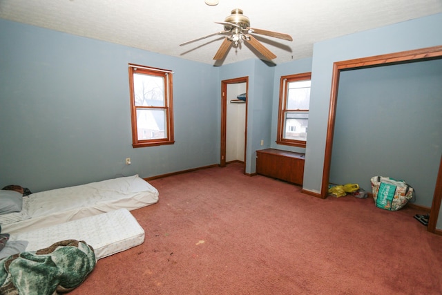 bedroom with a textured ceiling, carpet floors, ceiling fan, and baseboards